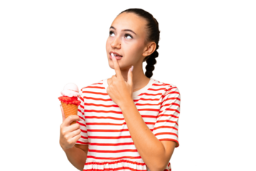 Young Arab woman with a cornet ice cream over isolated background having doubts while looking up