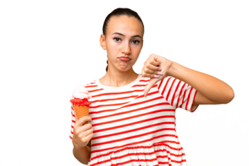 Young Arab woman with a cornet ice cream over isolated background showing thumb down with negative expression