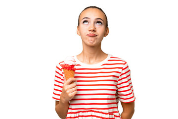 Young Arab woman with a cornet ice cream over isolated background and looking up