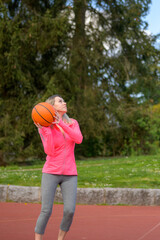 Fototapeta na wymiar Woman playing basketball on a sports field