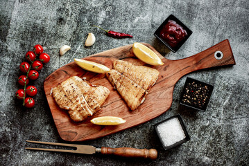 grilled pangasius white fish fillet with spices on a stone background 