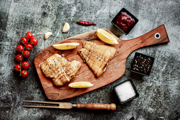 grilled pangasius white fish fillet with spices on a stone background 