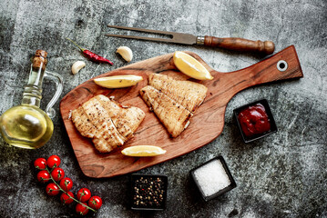 grilled pangasius white fish fillet with spices on a stone background 