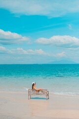 Fototapeta na wymiar Alone woman sitting on a chair enjoying the blue ocean view at the beach. travel and summer vacation pictures at Kho mun nork ,Thailand