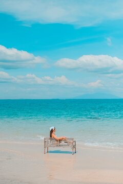 Alone woman sitting on a chair enjoying the blue ocean view at the beach. travel and summer vacation pictures at Kho mun nork ,Thailand