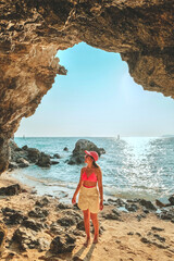 Women standing on a rock at the cave entrance Look at the sea and beautiful views. at sunset...