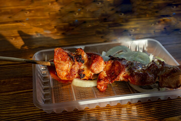 Plastic plate for barbecue with onions on a wooden table
