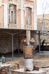An old Turkish wood-burning samovar with two copper kettles near a cafe for vacationing tourists.