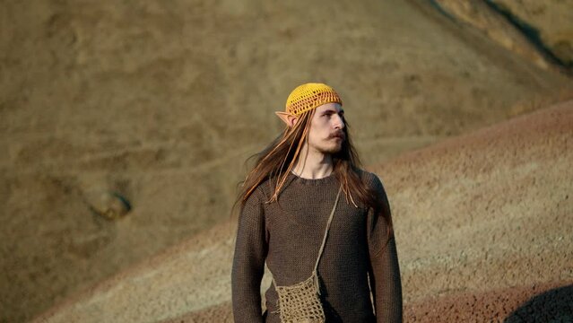 Portrait of serious handsome young adult man with beard in Desert at golden hour .