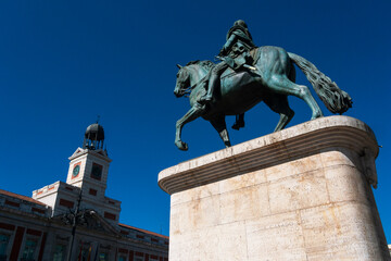 Naklejka premium Vista del monumento a Carlos III y de la sede de la comunidad de Madrid en la puerta del sol.