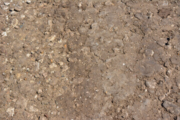 A close up of a brown dirt texture with small rocks and dirt isolated