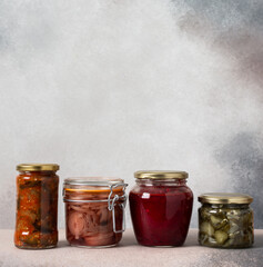 Preserving vegetables for the winter, canned vegetables in jars on a light background, pickled or fermented vegetables, copy space