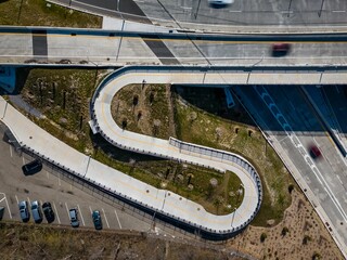 Aerial shot of a curving road with a winding pedestrian pathway in Queens, New York.