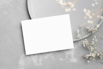 Blank save the date invitation card mockup with flowers decor on grey