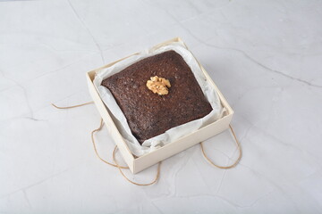 premium freshly baked dark cocoa chocolate brownie square cake with walnut in wood bento box on white marble halal food sweet dessert menu for pastry cafe shop