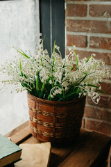 White lilies of the valley in a wicker basket