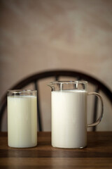 나무 식탁위에 놓인 유리병에 담긴 흰 우유