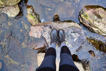 water stepping stones walking over in boots
