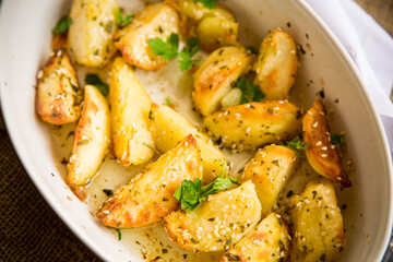 potatoes baked with sesame seeds, herbs and spices in the oven