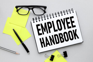 employee handbook text on notepad page near bright stickers.