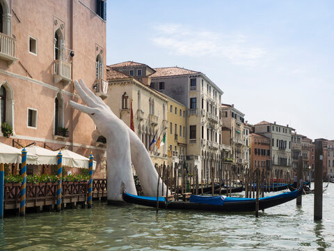 VENICE, ITALY - SEPTEMBER 13, 2017:  Sculpture titled "Support" by artist Lorenzo Quinn  for the 2017 Venice Biennale.  The Giant hands support the sides of the Ca’ Sagredo Hotel on the Grand Canal