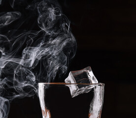 Glass of whiskey with ice on black