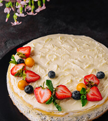 cheesecake with poppy seeds decorated with fresh strawberries