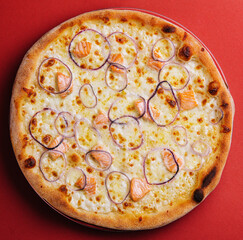 Pizza with salmon on red background