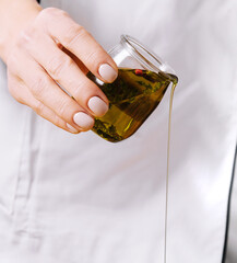 Chef pouring olive oil close up