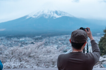 Male photographer taking photo of Mt. Fuji, view from behind