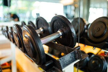 Fototapeta na wymiar Various weight of dumbbells on a rack in indoor fitness center or gym.