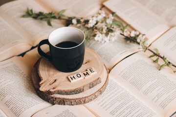 book and a cup of coffee with spring twig blooming and word home