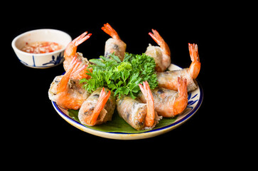 Traditional fried vietnamese spring rolls with shrimps and pork, rice paper on black background