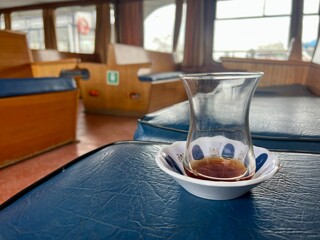 empty Turkish tea glass on seat of a ferry interior in Turkey