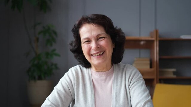 Happy middle aged senior woman talk on video call with friends family. Laughing mature old senior grandmother having fun speaking with grown up children online. Headshot portrait selfie webcamera view