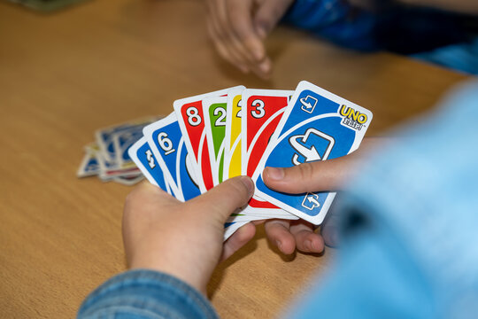 cartes du jeu Uno dans des mains d'un adolescent