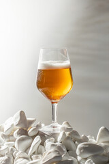 Close-up glass cold beer with foam and water drops with natural palm shadows