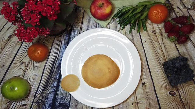 Cute pig pancake, mini pancakes assemble pig character on a white plate, wooden table with fruits. High quality 4k footage