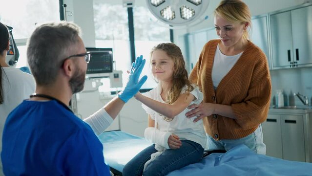 Mature doctor giving gypsum to little girl.