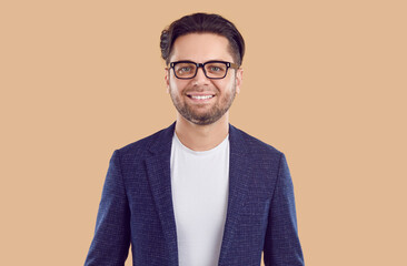 Portrait of young confident unshaven brunet smiling man in blue jacket, white t-shirt and glasses...