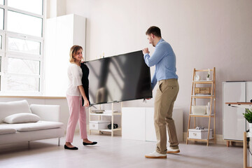 Smiling Young Couple Carrying New Television