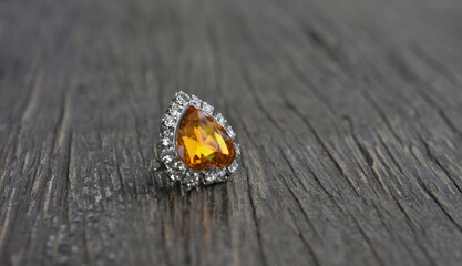 Fototapeta na wymiar Yellow gem Beautiful earring on the wooden floor