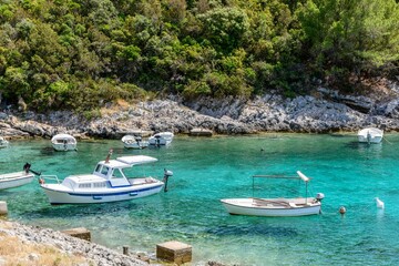 Boats anchored in cove with clear turquoise water at Rasohatica beach on Korcula island in Croatia
