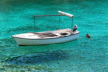 Naklejka premium White boat on transparent crystal clear turquoise water