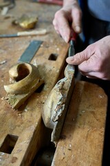 Craftsman carving a piece of wood to make a golden frame