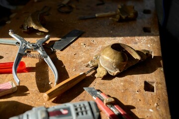 Closeup of craftsmanship tools and a piece of golden wooden frame on a table