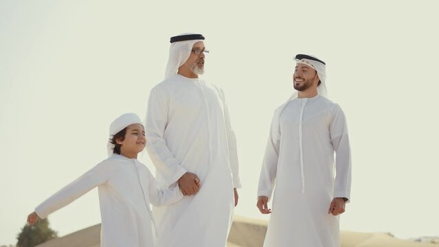 Three generation family spending time in the desert making a safari in Dubai. Concept about middle eastern cultures and lifestyle in the emirates