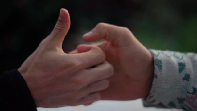 Slow motion of two men playing thumb war on the blurred background