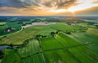 Aerial view of a rural landscape featuring a river snaking through green fields and farmland