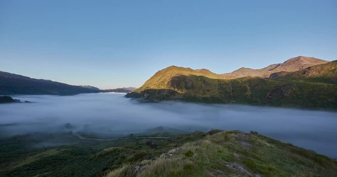 Time Lapse of morning fog and sunrise from Snowdon lookout with the Snowdon mountain range in background, Wales, UK